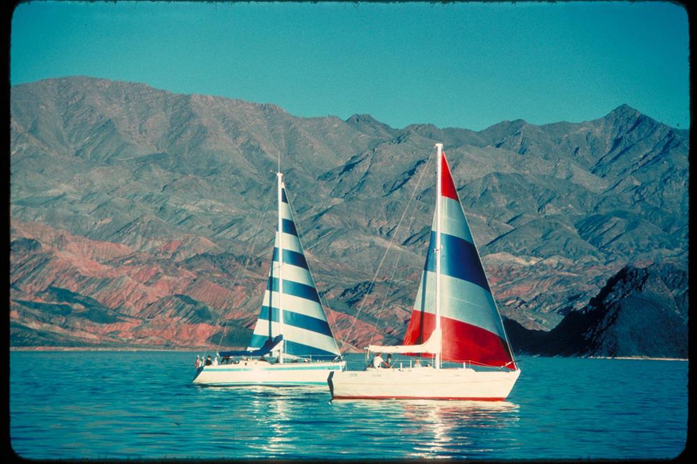 Two sailboats on Lake Mead with desert mountains in the distance